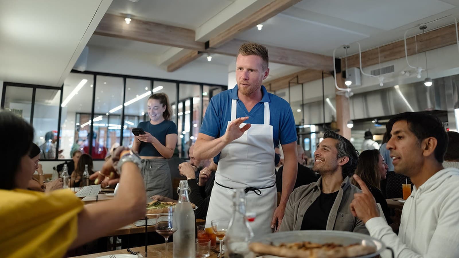 The dining room at Flour + Water Pizzeria in North Beach, San Francisco, with the open kitchen behind